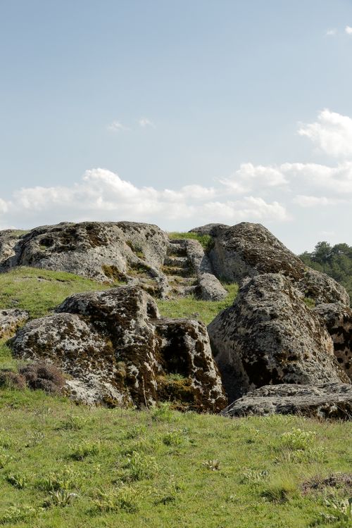 Free Explore ancient stone steps in a serene rural landscape under a blue sky. Stock Photo