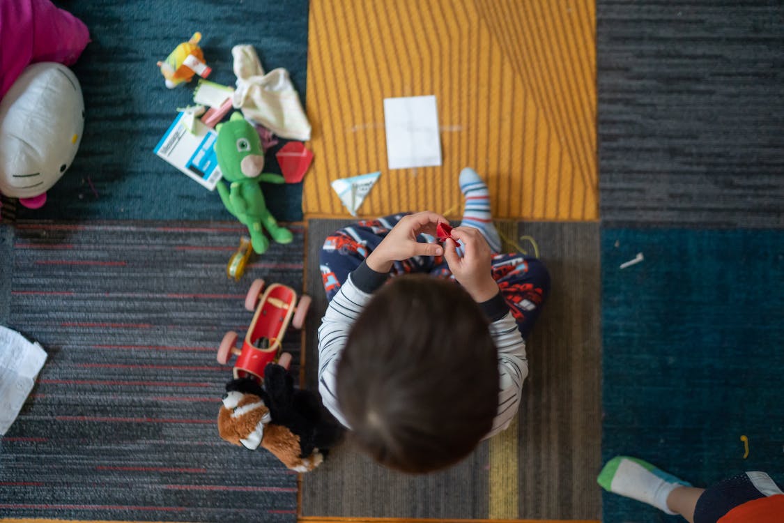 Free Top-view Photography of Toddler Playing With Toy Stock Photo