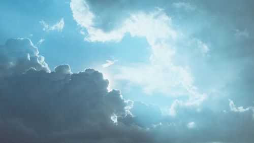 Free A captivating image of a bright blue sky with dramatic clouds illuminated by sunlight. Stock Photo