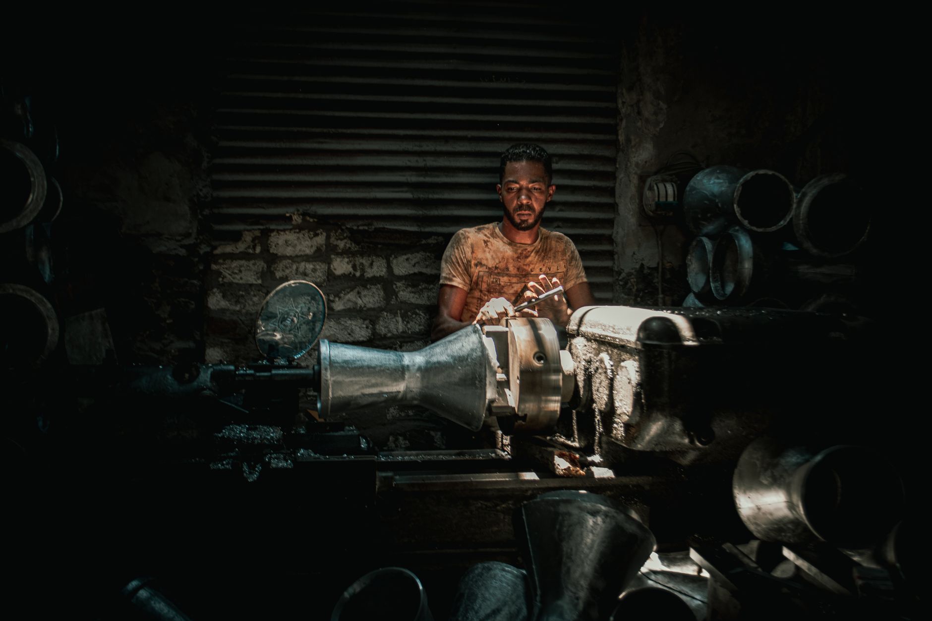 What to Look for When Buying a Used Press Brake插图2 Portrait of a man in a dimly lit industrial setting operating heavy machinery.