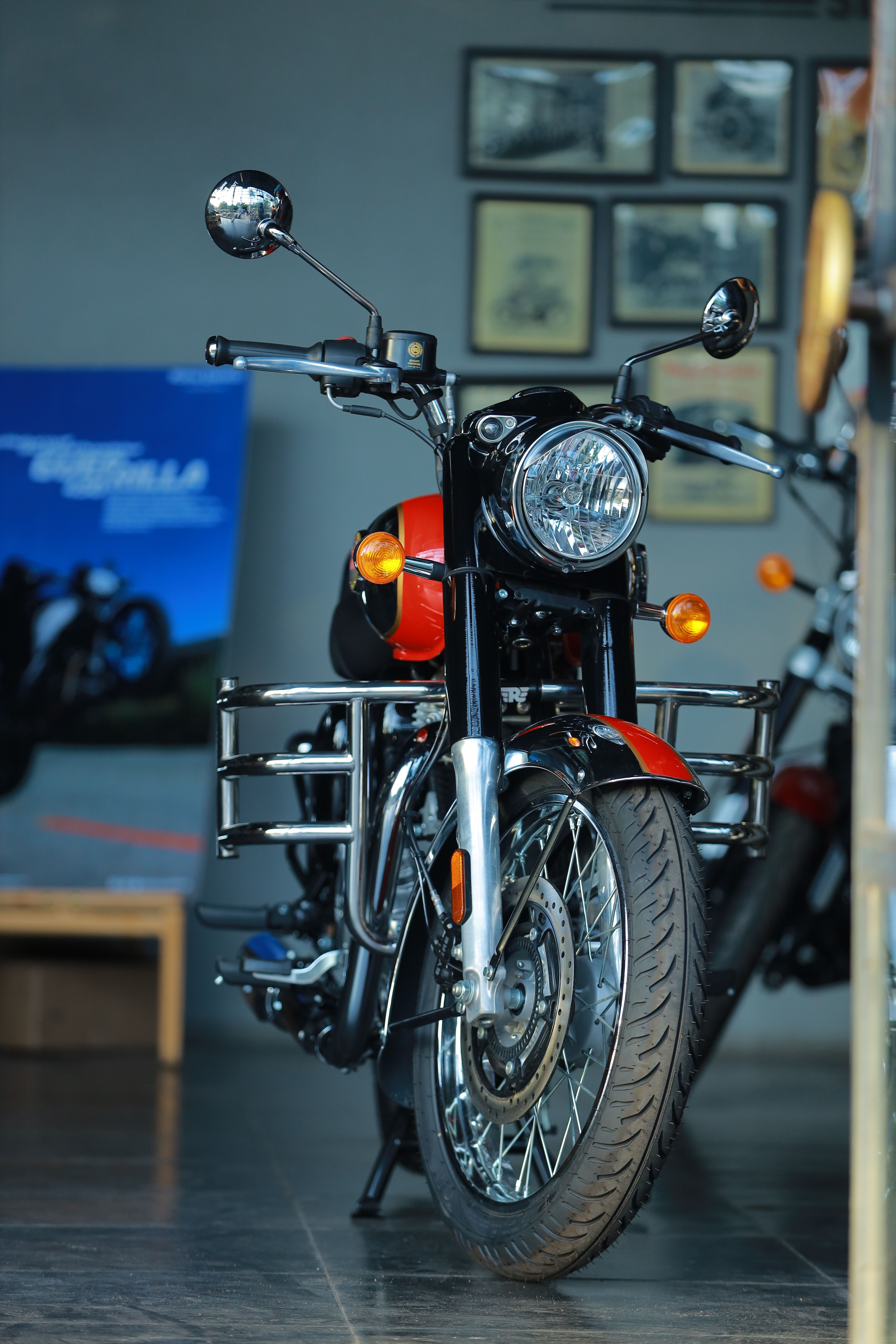 A vintage-style motorcycle exhibited indoors, highlighting its classic design elements.