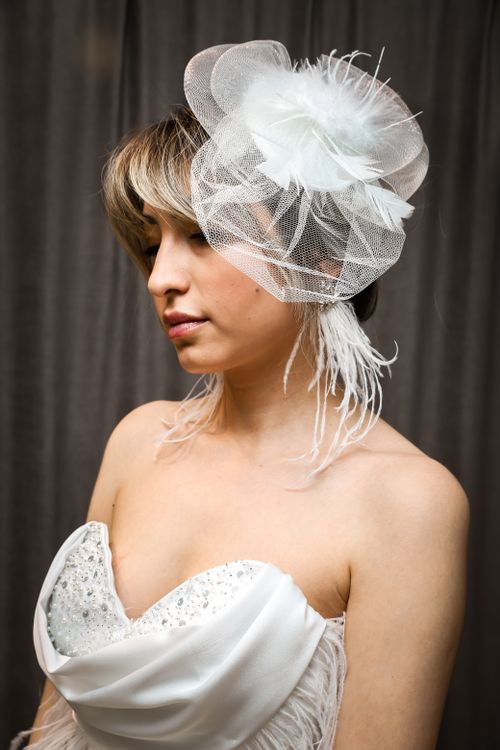 Free Stylish bridal portrait featuring an elegant feathered fascinator on a young woman in a photo studio. Stock Photo