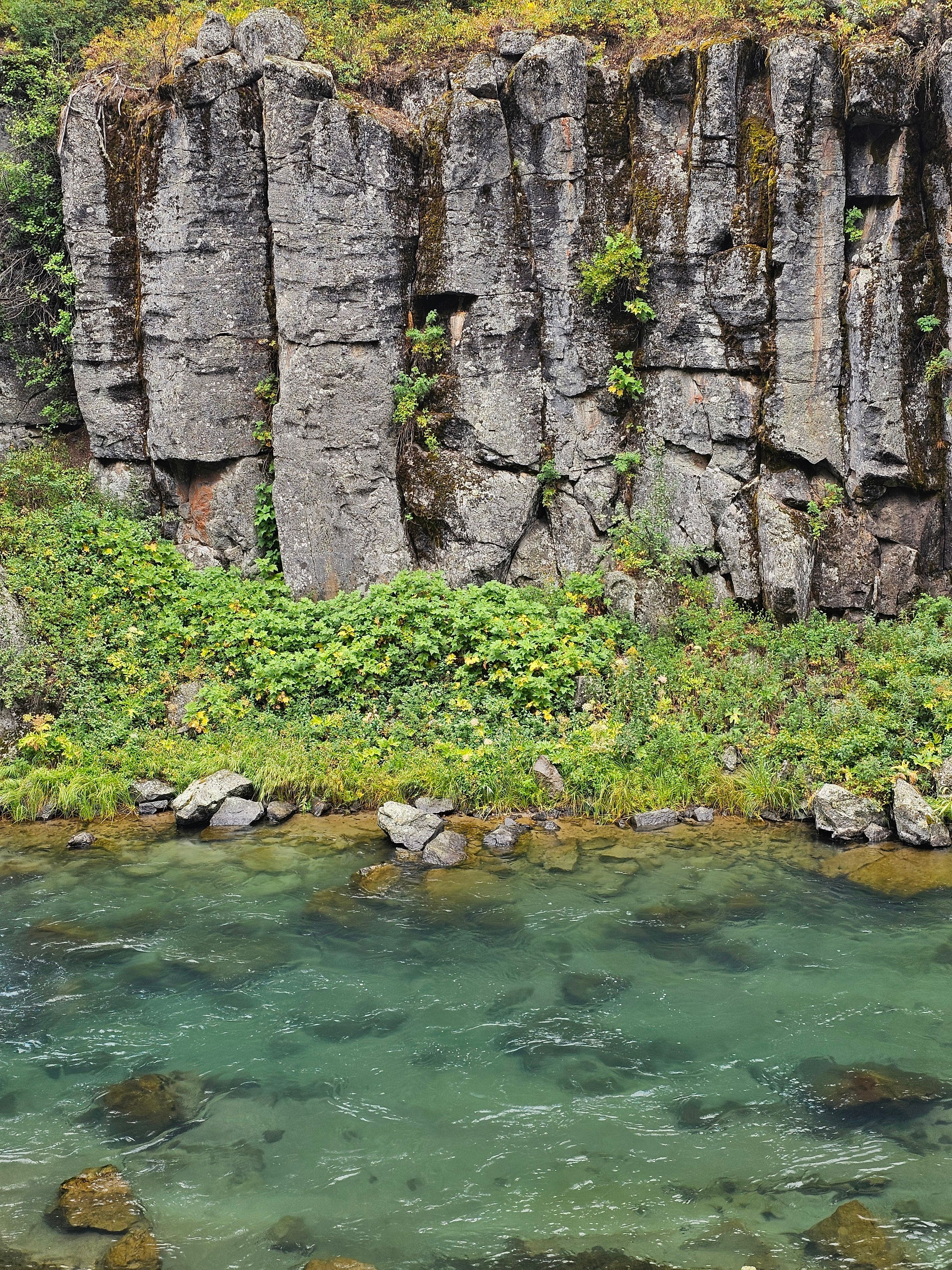 A river is flowing through a rocky cliff · Free Stock Photo