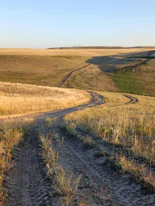 Free A beautiful countryside landscape featuring a winding dirt path through expansive fields. Stock Photo