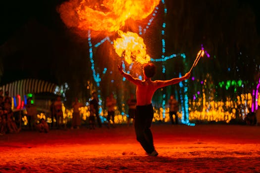 A talented fire performer creating a dazzling display with flames at a vibrant night festival.