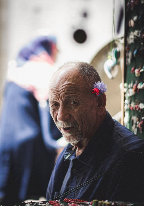 Free Portrait of an elderly Tunisian man selling jewelry in a bustling marketplace. Stock Photo