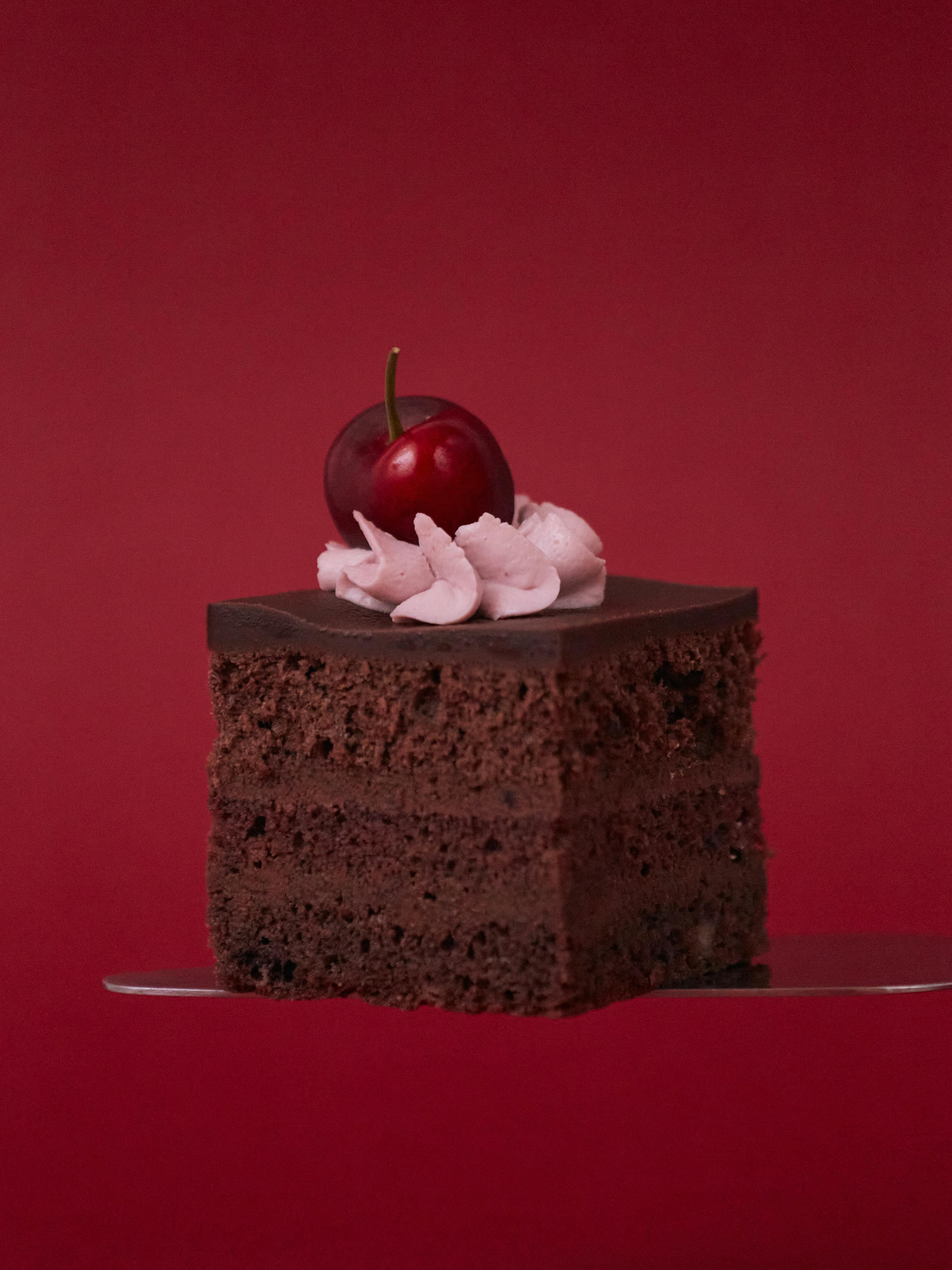 Elegant chocolate cake slice topped with a cherry, perfect for dessert inspiration.