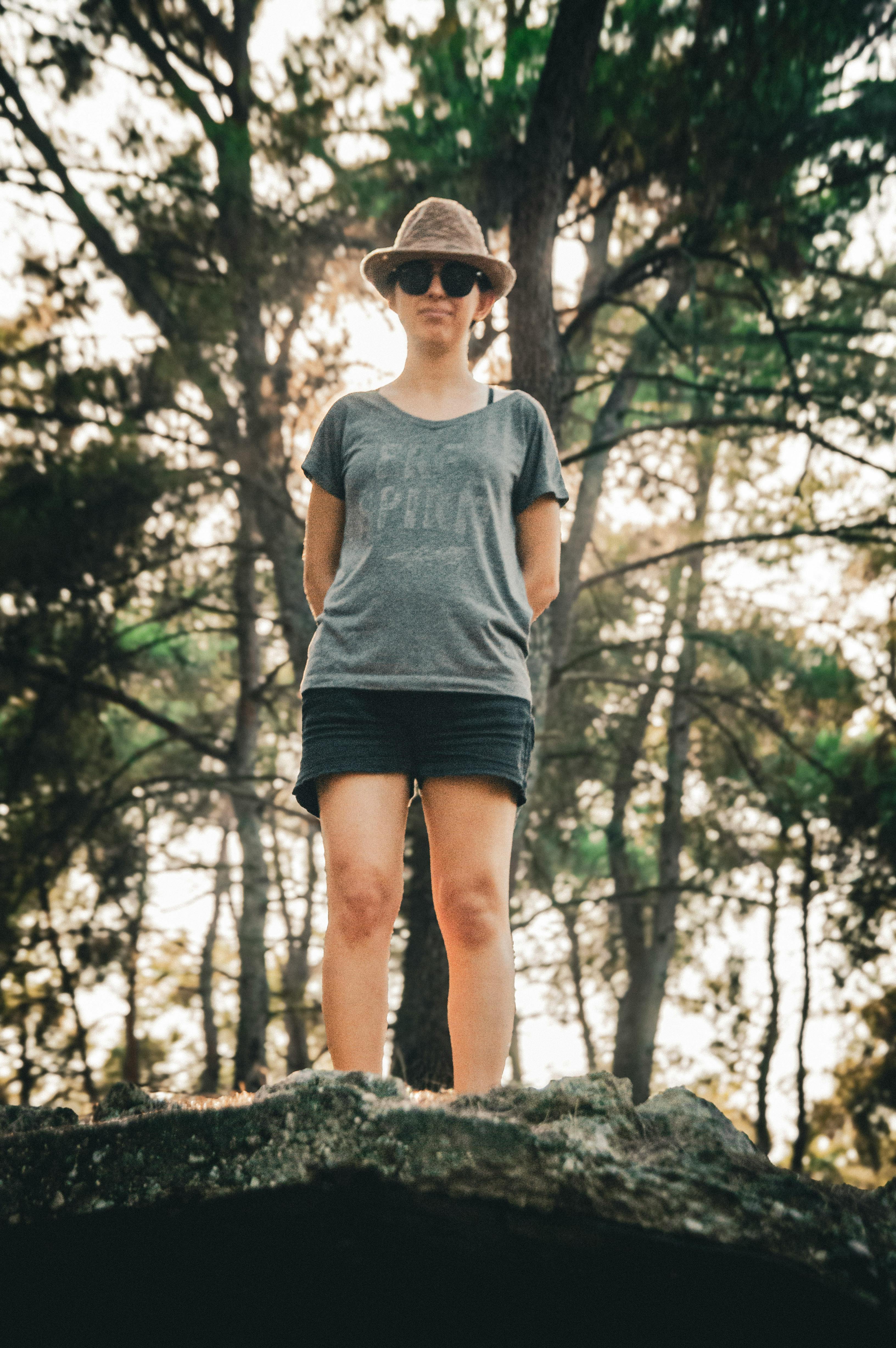 a woman standing on a rock in the woods