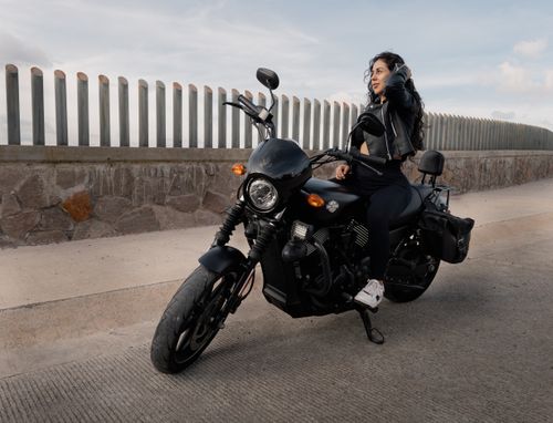 Free A confident woman enjoys a ride on a black motorcycle along a scenic road in San Luis Potosí, Mexico. Stock Photo