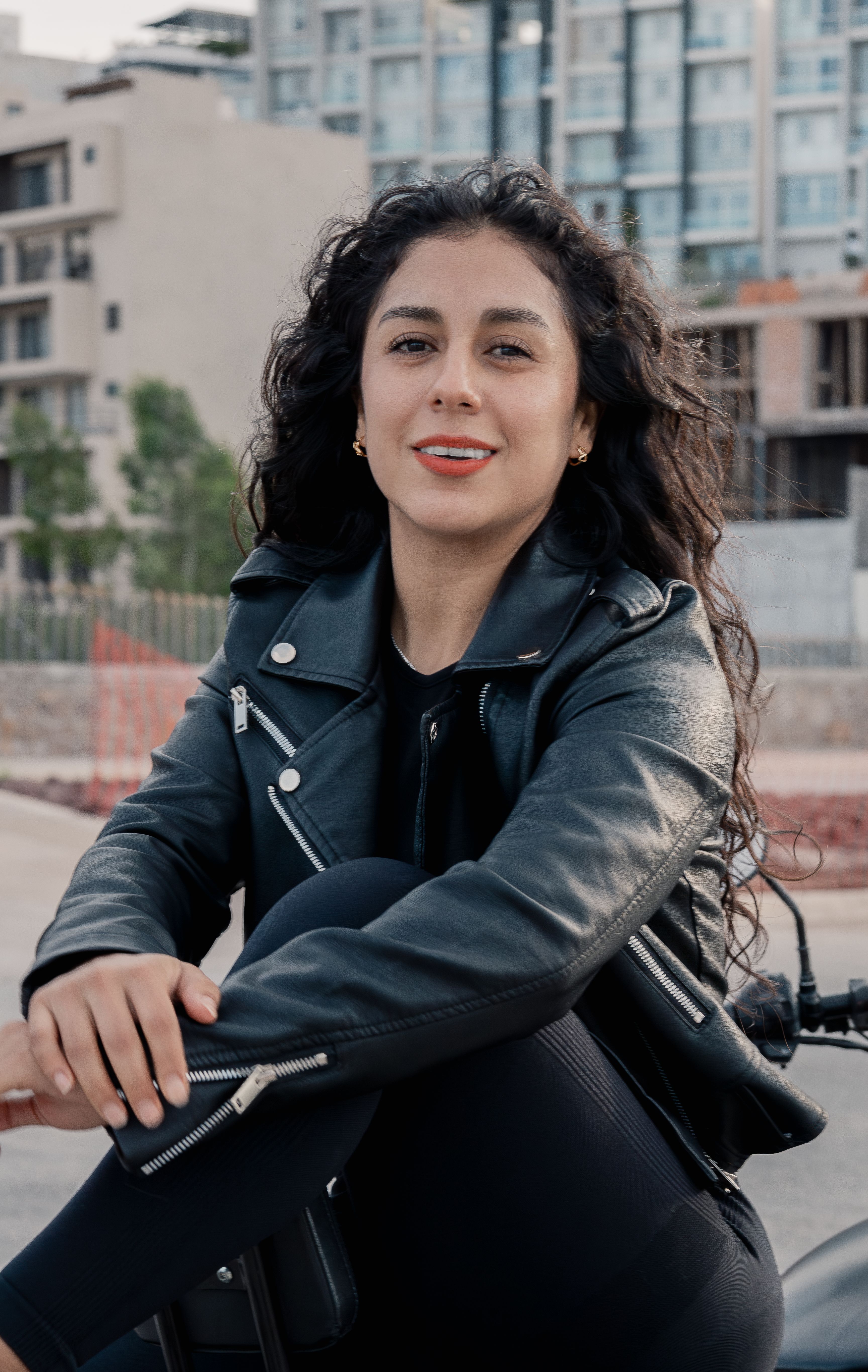 Empowered woman in leather jacket on motorcycle in urban San Luis Potosí.