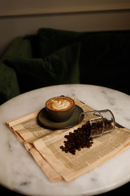 A coffee cup sits on top of a newspaper