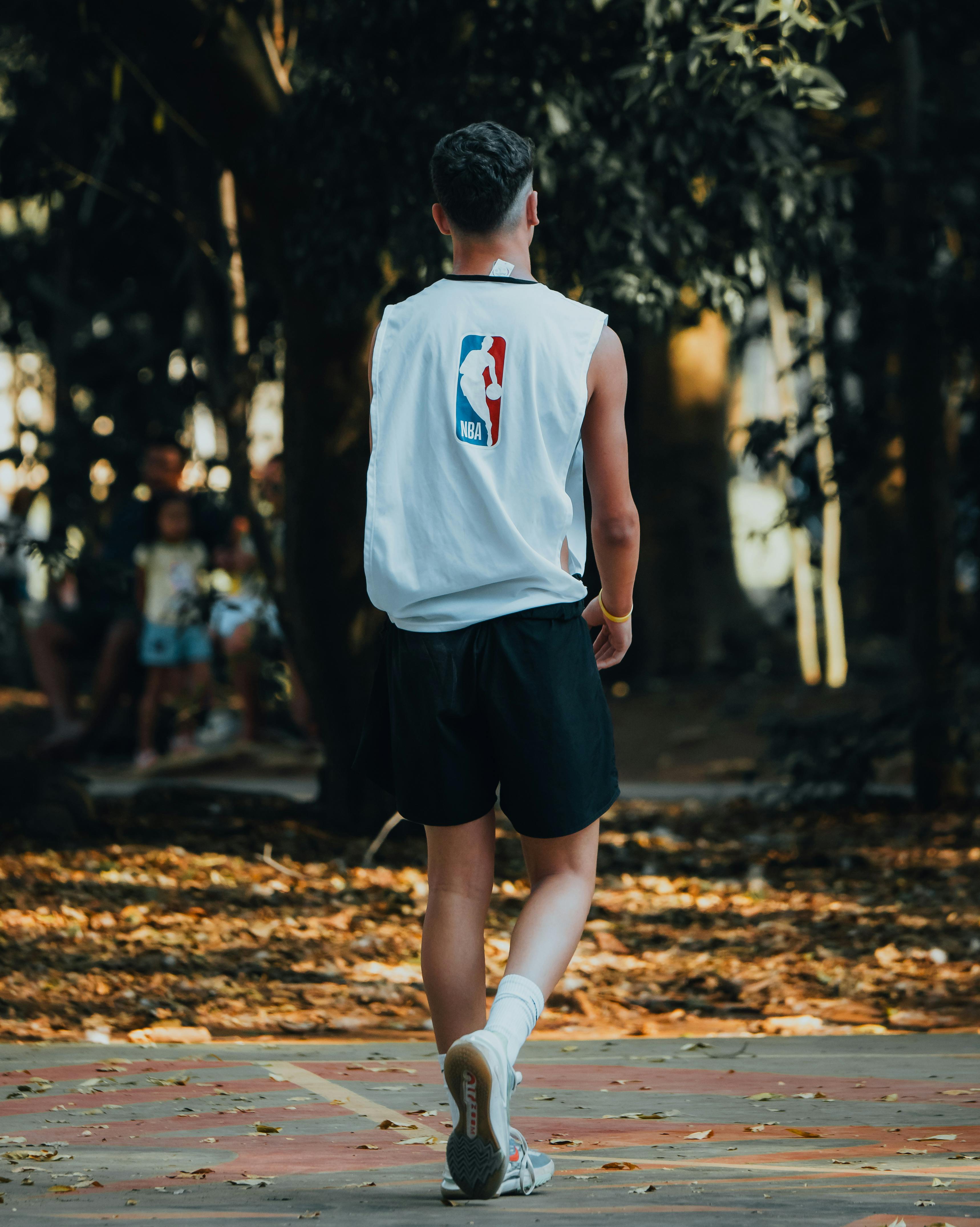 a man walking down a path with a basketball