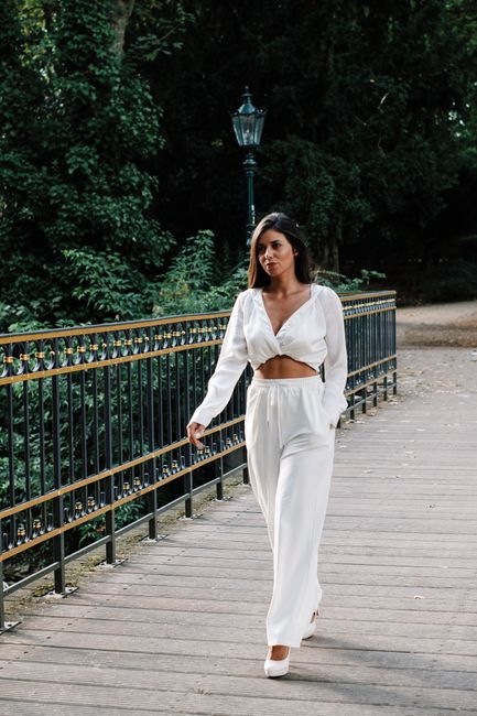 A fashionable woman in Düsseldorf walking confidently in a chic white ensemble.