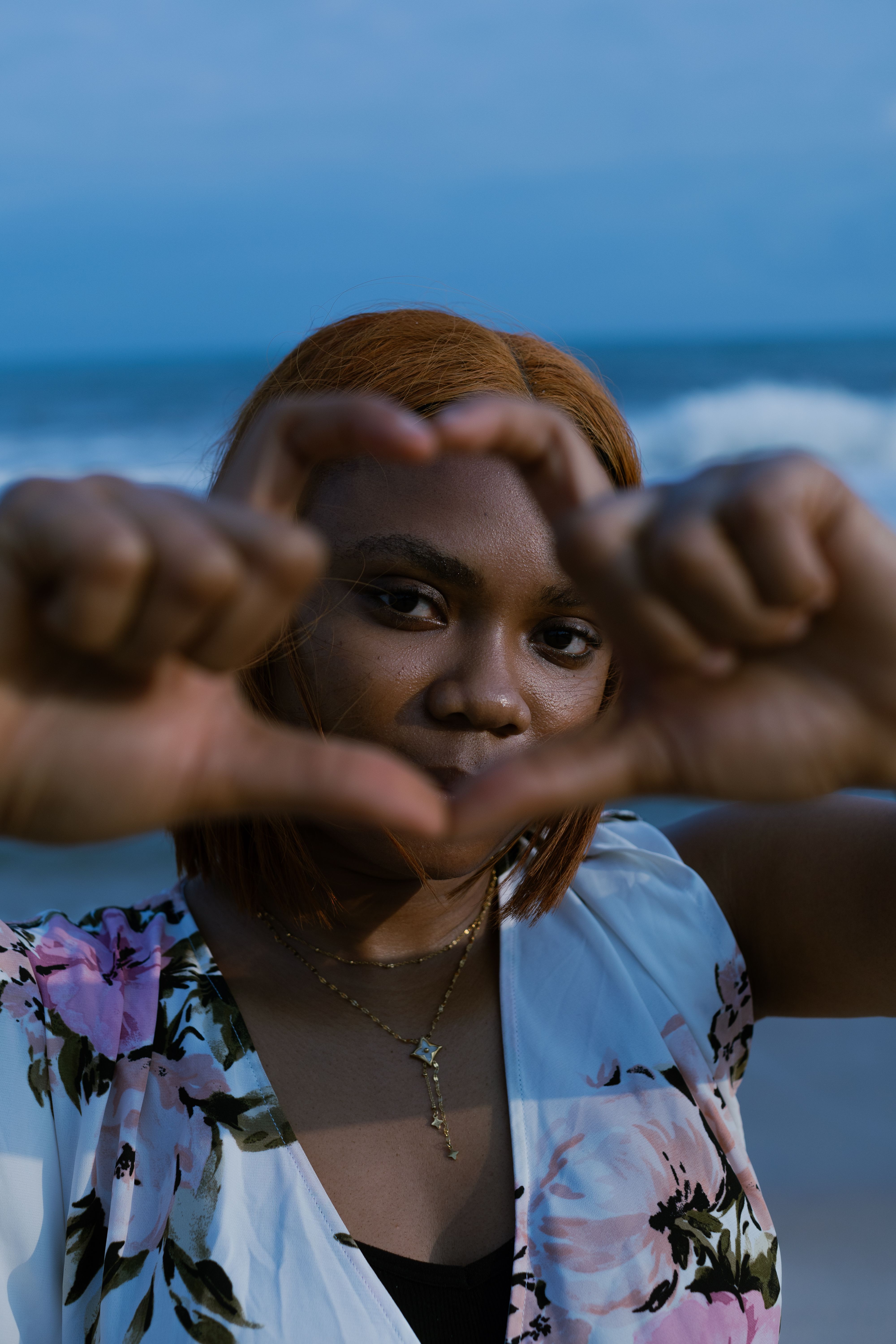 A woman making a heart shape with her hands · Free Stock Photo