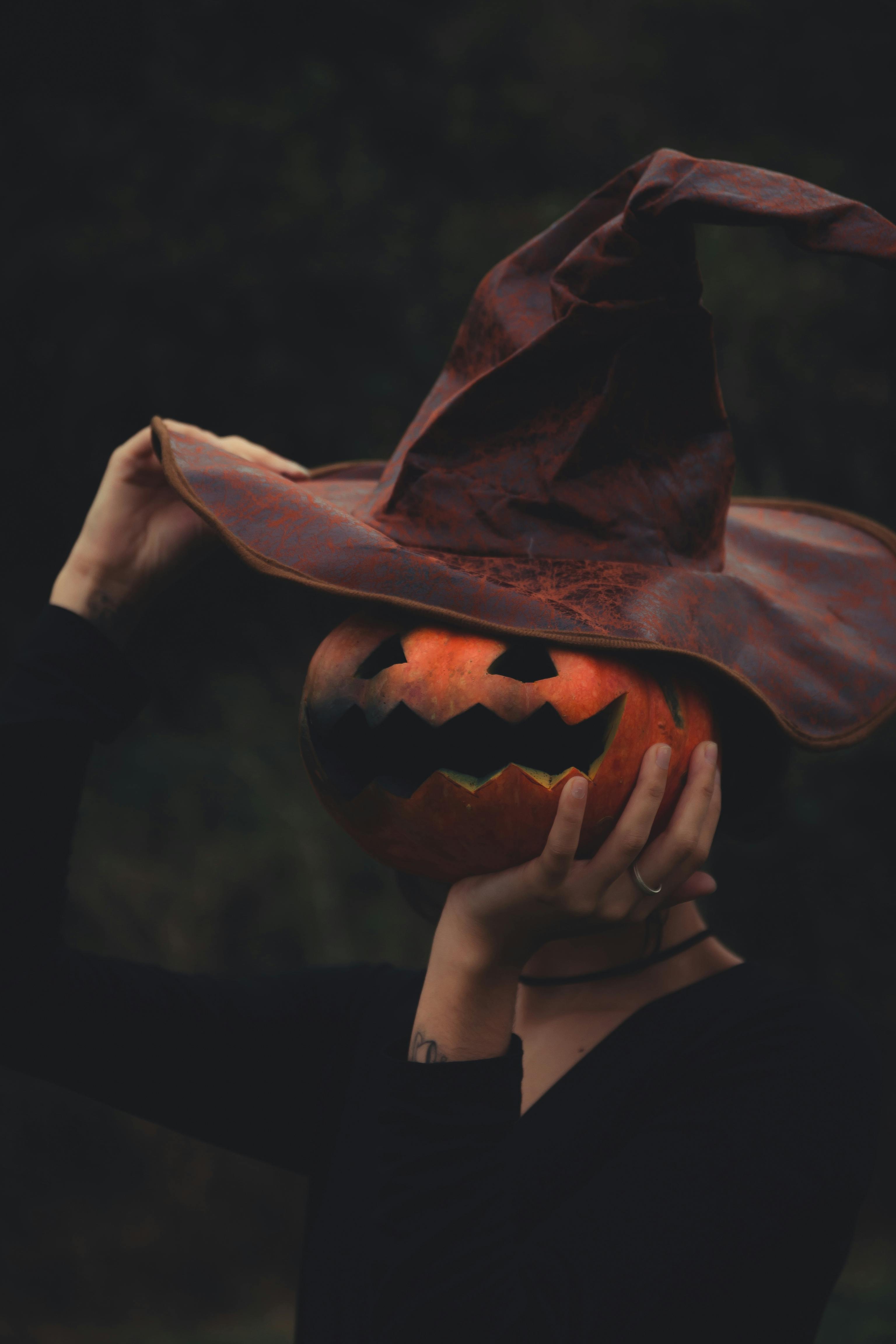 A spooky scene with a pumpkin wearing a witch hat, embodying Halloween spirit.