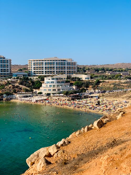 Free A stunning view of a coastal resort with a sandy beach and clear blue waters, perfect for summer vacation. Stock Photo