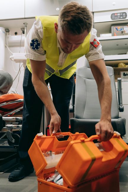 Fotomural Paramédico organizando el equipo dentro de una ambulancia, asegurando la preparación para emergencias.