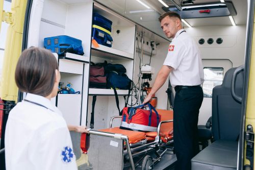 Free Two paramedics organizing medical supplies in an ambulance for emergency readiness. Stock Photo