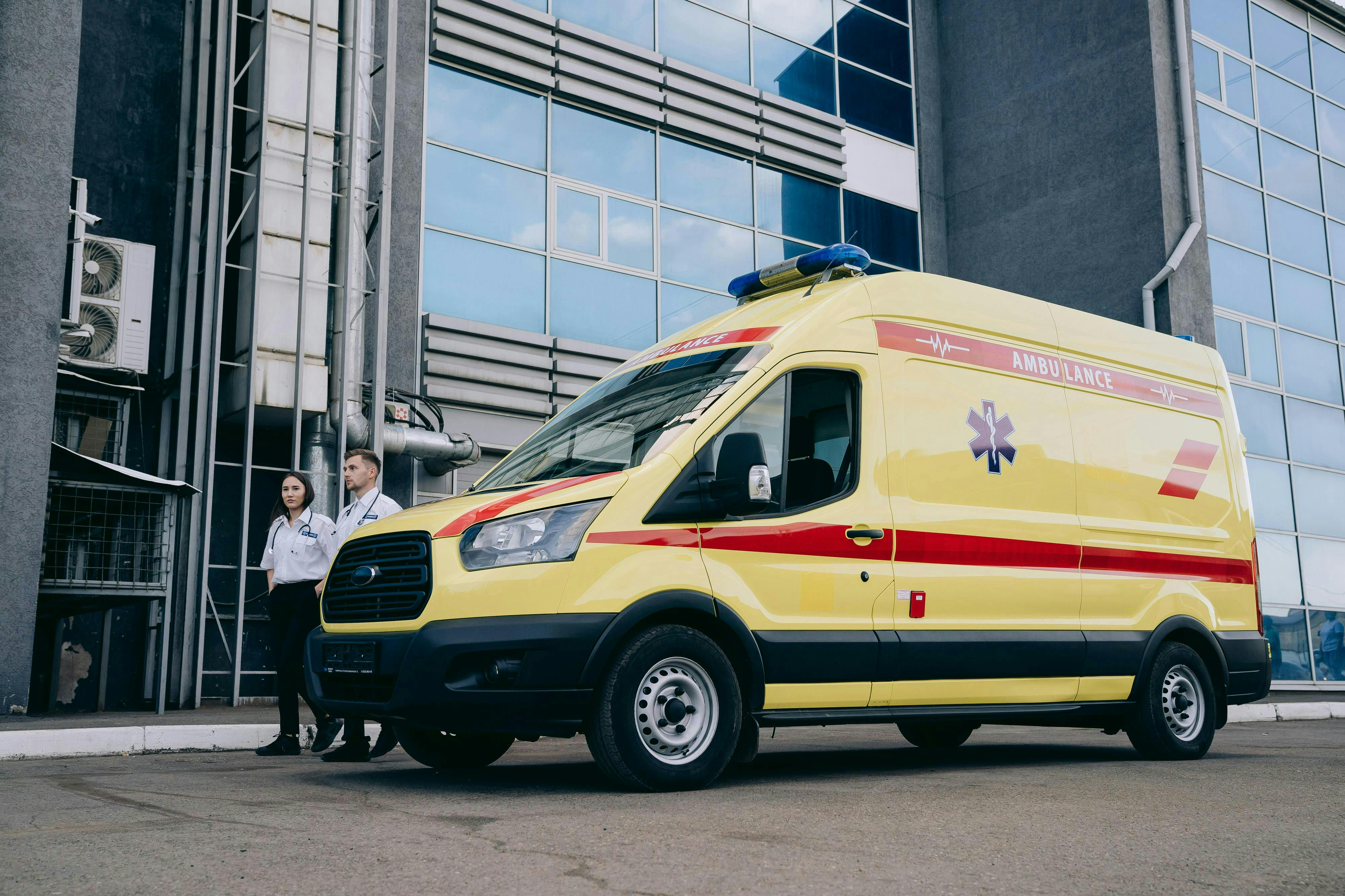 paramedics and ambulance by modern building