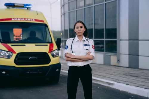 Free A female paramedic standing confidently by an ambulance, showcasing healthcare professionalism. Stock Photo