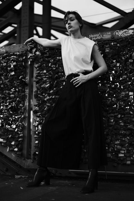 Elegant fashion portrait of a woman in Cologne's urban setting, showcasing modern style.