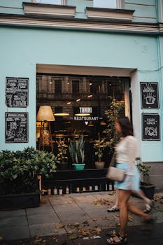 Captivating restaurant facade with greenery and passing pedestrian, showcasing urban outdoor atmosphere.