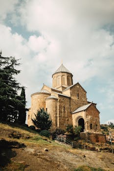 Stunning view of an ancient Georgian church showcasing classic architecture against a serene sky.