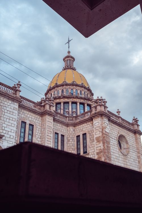 Free A stunning view of an ancient church dome showcasing intricate architecture against a cloudy sky. Stock Photo