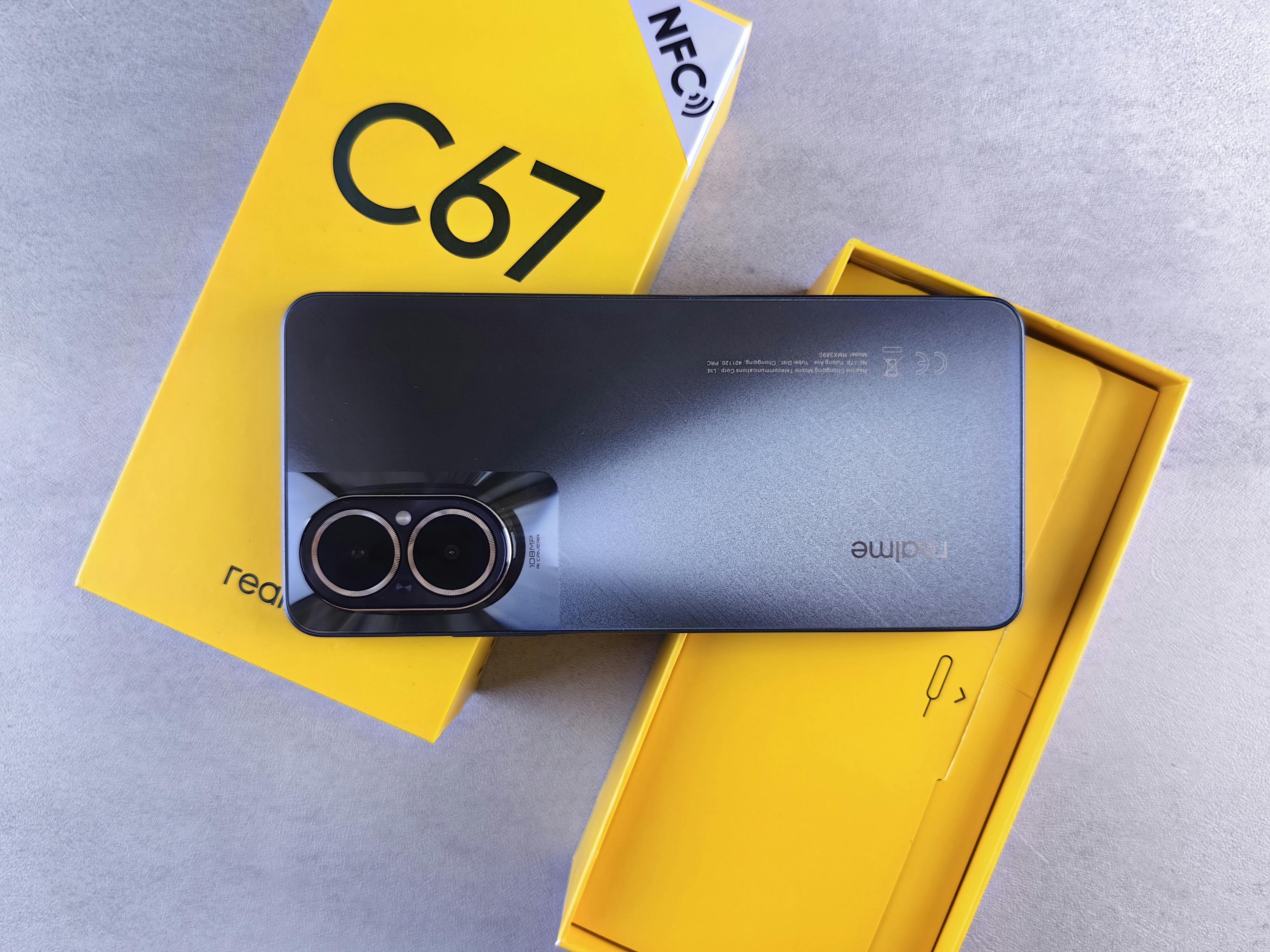 Modern smartphone placed on vibrant yellow packaging, showcasing design and branding.