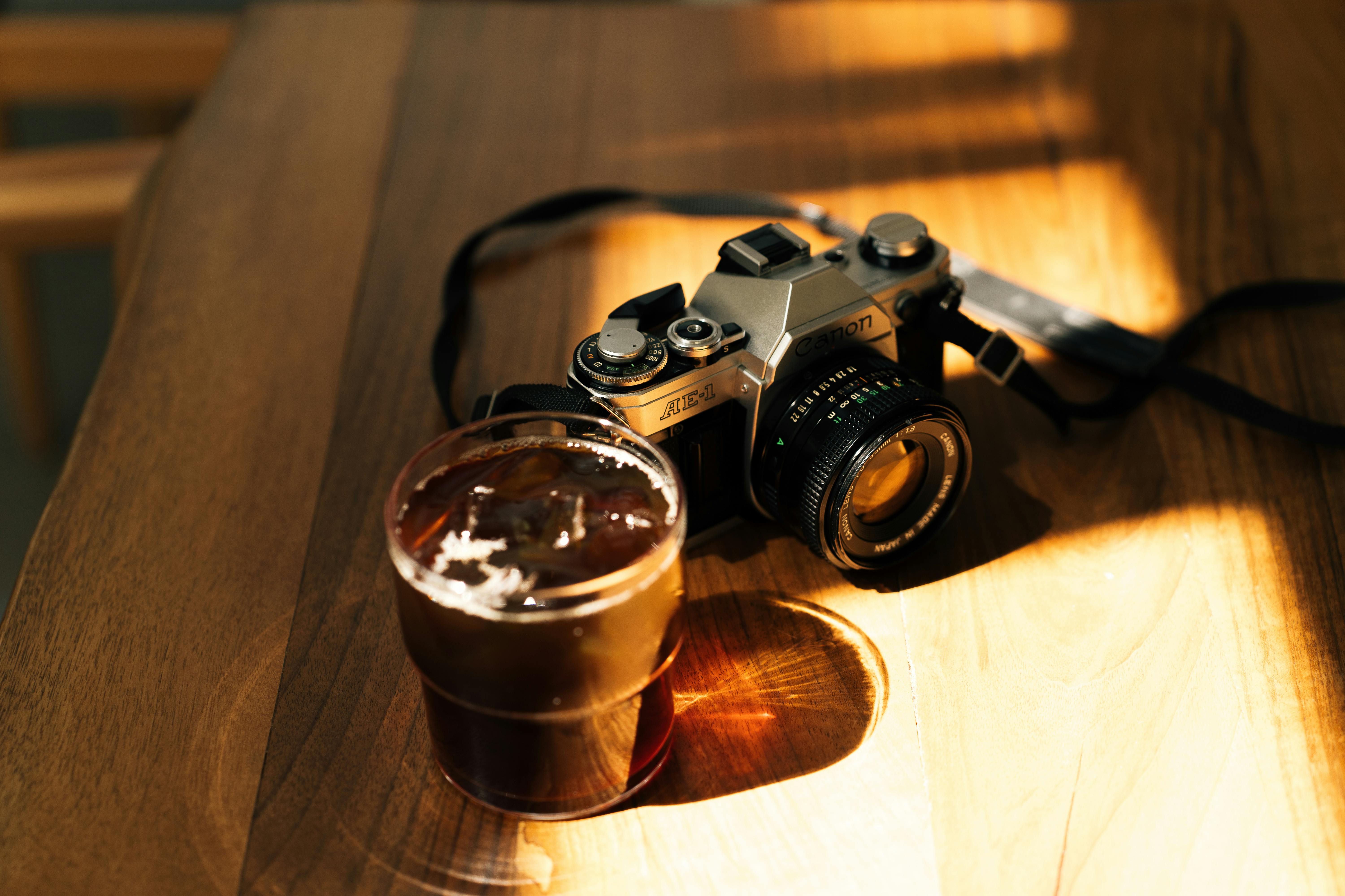 a camera and a glass of beer on a table