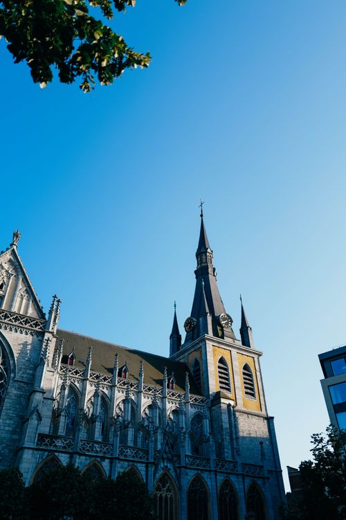 Free Stunning view of a classic Gothic cathedral tower against a clear blue sky. Stock Photo