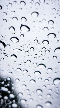 Close-up of raindrops on a glass window, creating an abstract and natural texture.