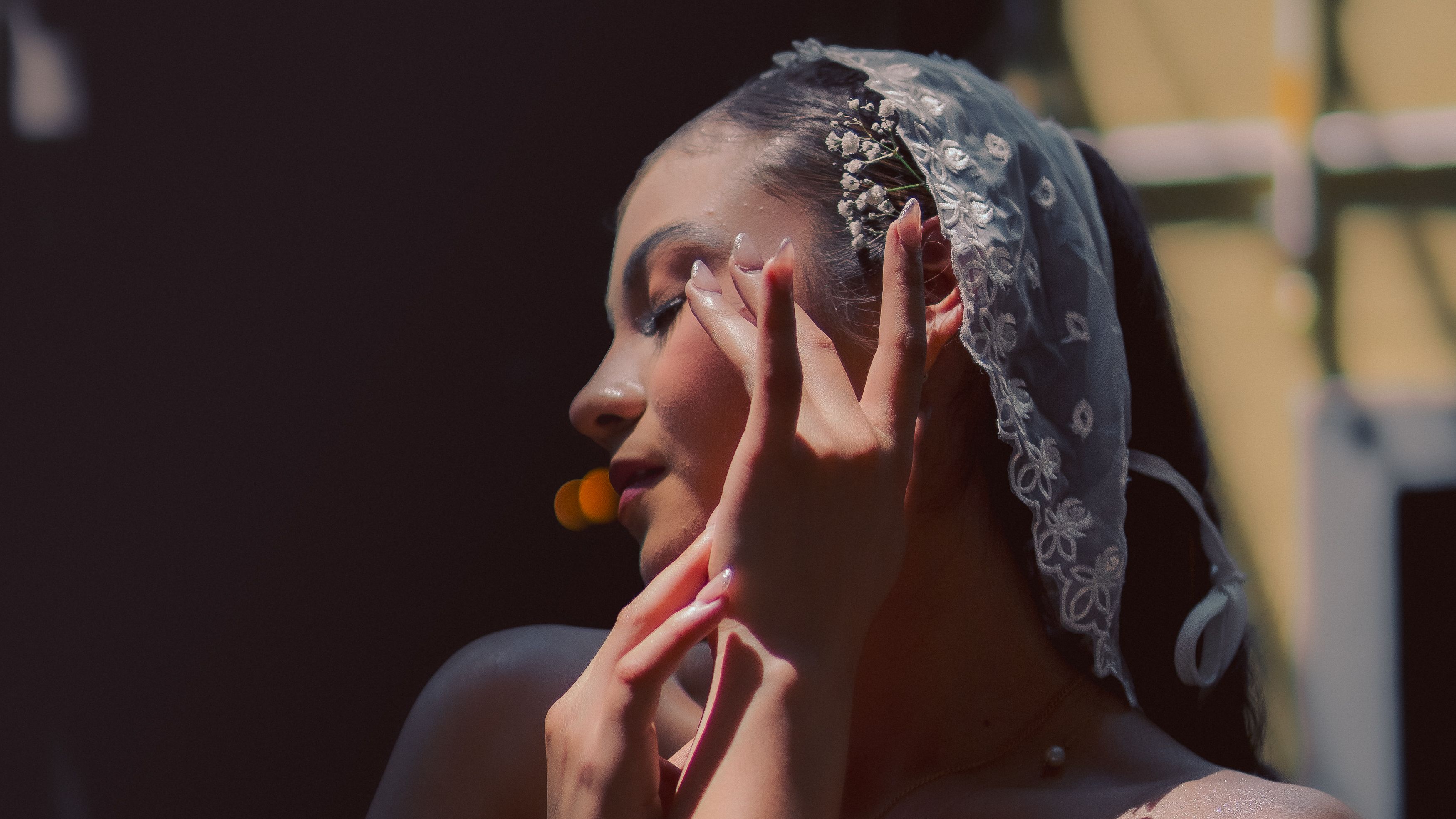 A woman in a veil is touching her face · Free Stock Photo