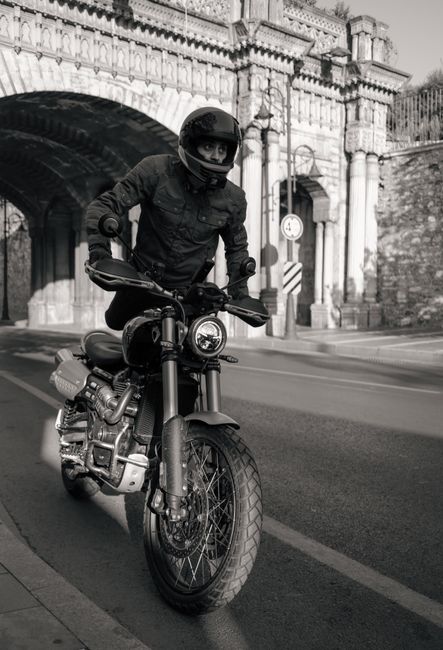 A motorcyclist navigates a historic street in İstanbul, showcasing vintage architecture and urban adventure.