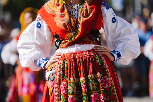 Close-up of a vibrant traditional dress worn at a cultural celebration outdoors.
