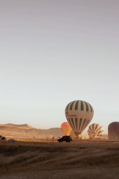 Hot air balloons rise at sunrise over a serene desert landscape, perfect for travel and adventure.