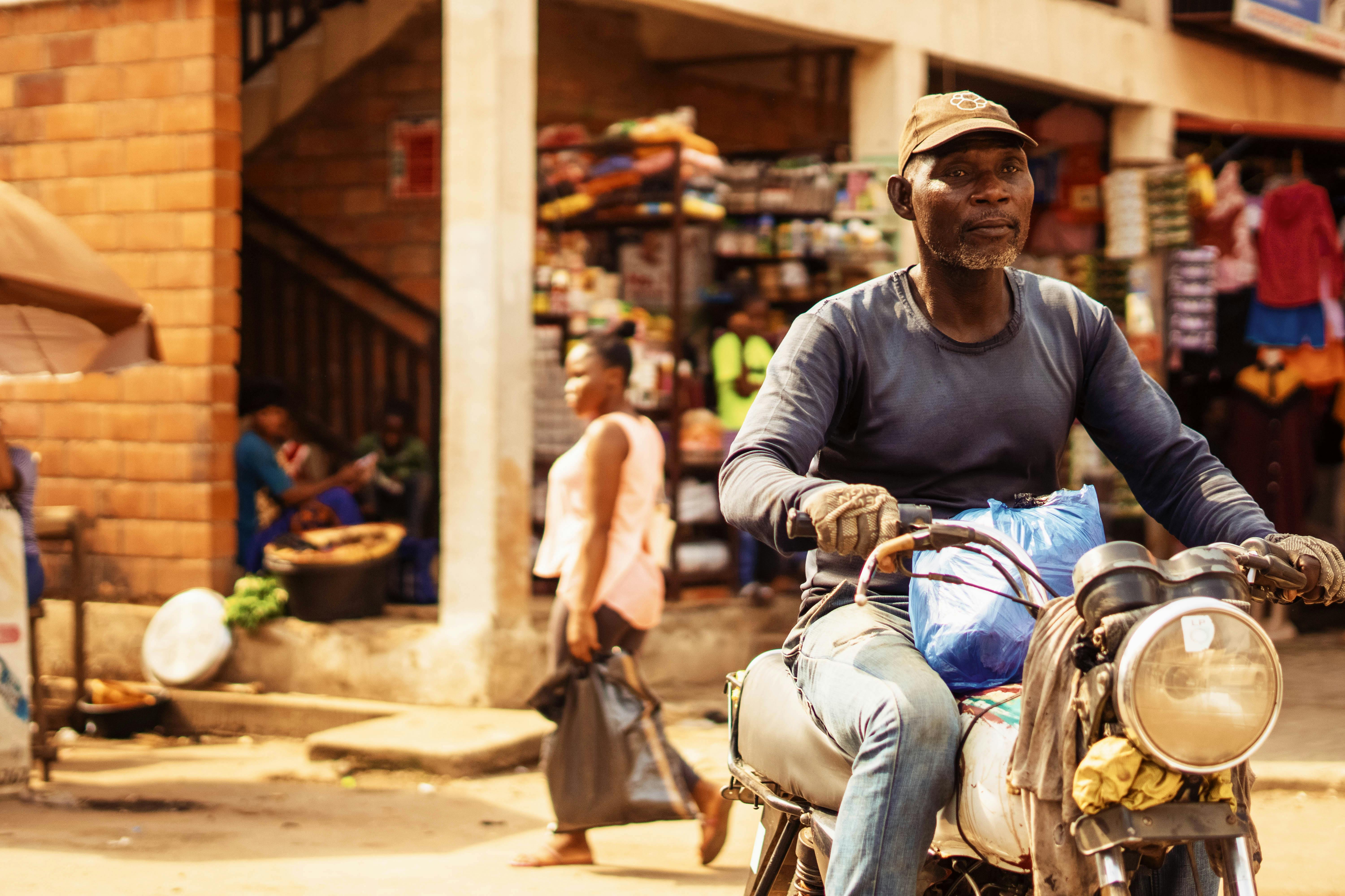 a man on a motorcycle in a busy market