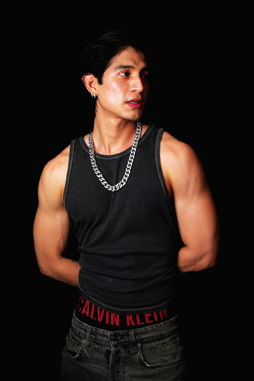 Free Stylish portrait of a muscular young man in a dark tank top, showcasing a contemporary fashion look. Stock Photo