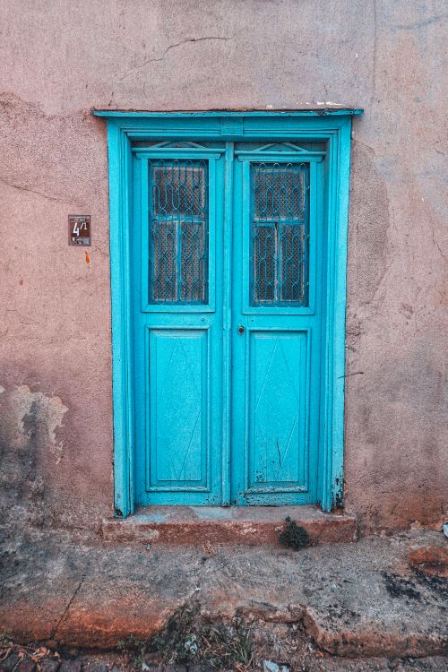 Free A vintage blue door set in a rustic wall captures timeless charm and character. Stock Photo