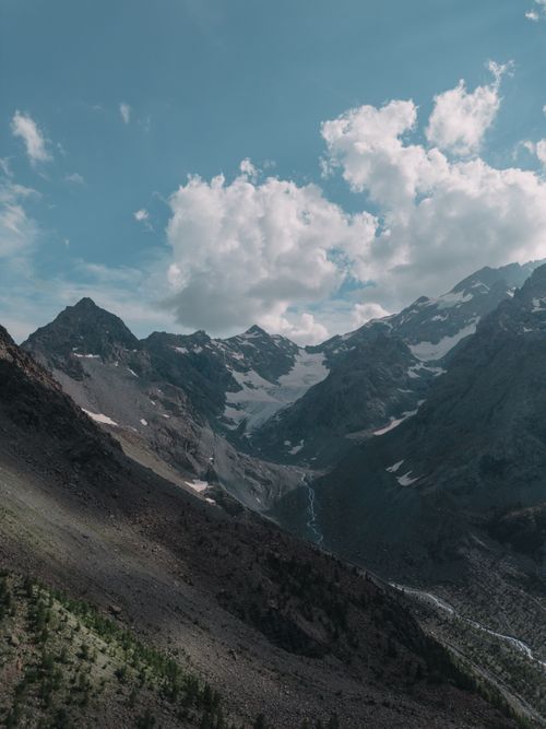 Free Explore a stunning mountain landscape with a glacier under a summer sky. Stock Photo