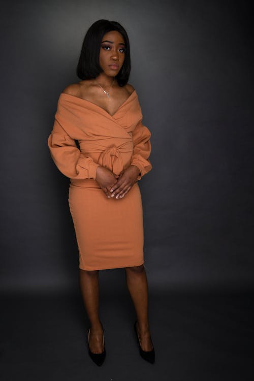 Woman In Brown Off Shoulder Dress Standing on Focus Photography