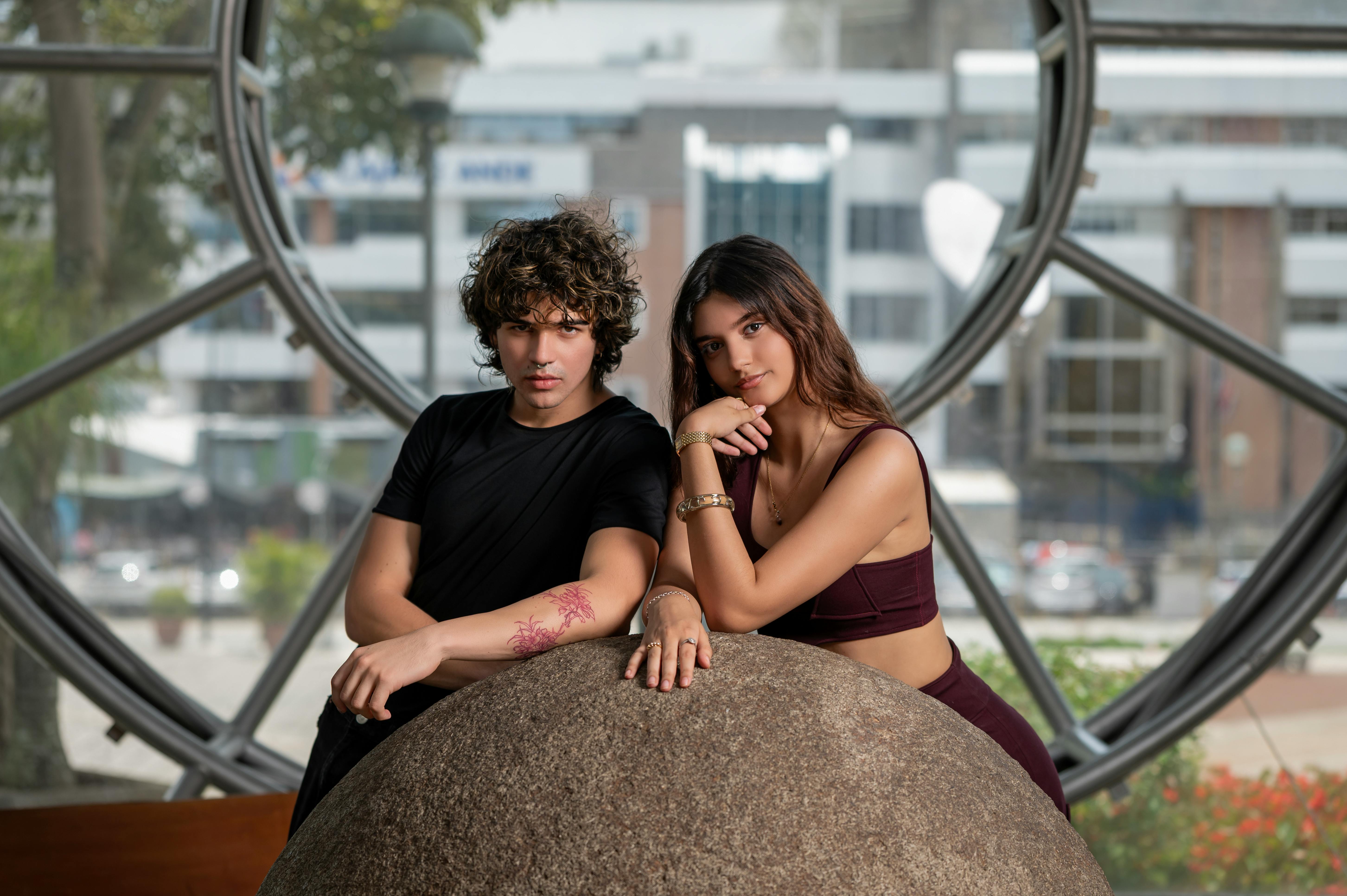 Young couple posing together in an urban environment, showcasing fashion and modern style.