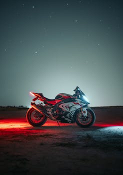 Powerful motorcycle illuminated by headlights on a starry night, showcasing speed and style.