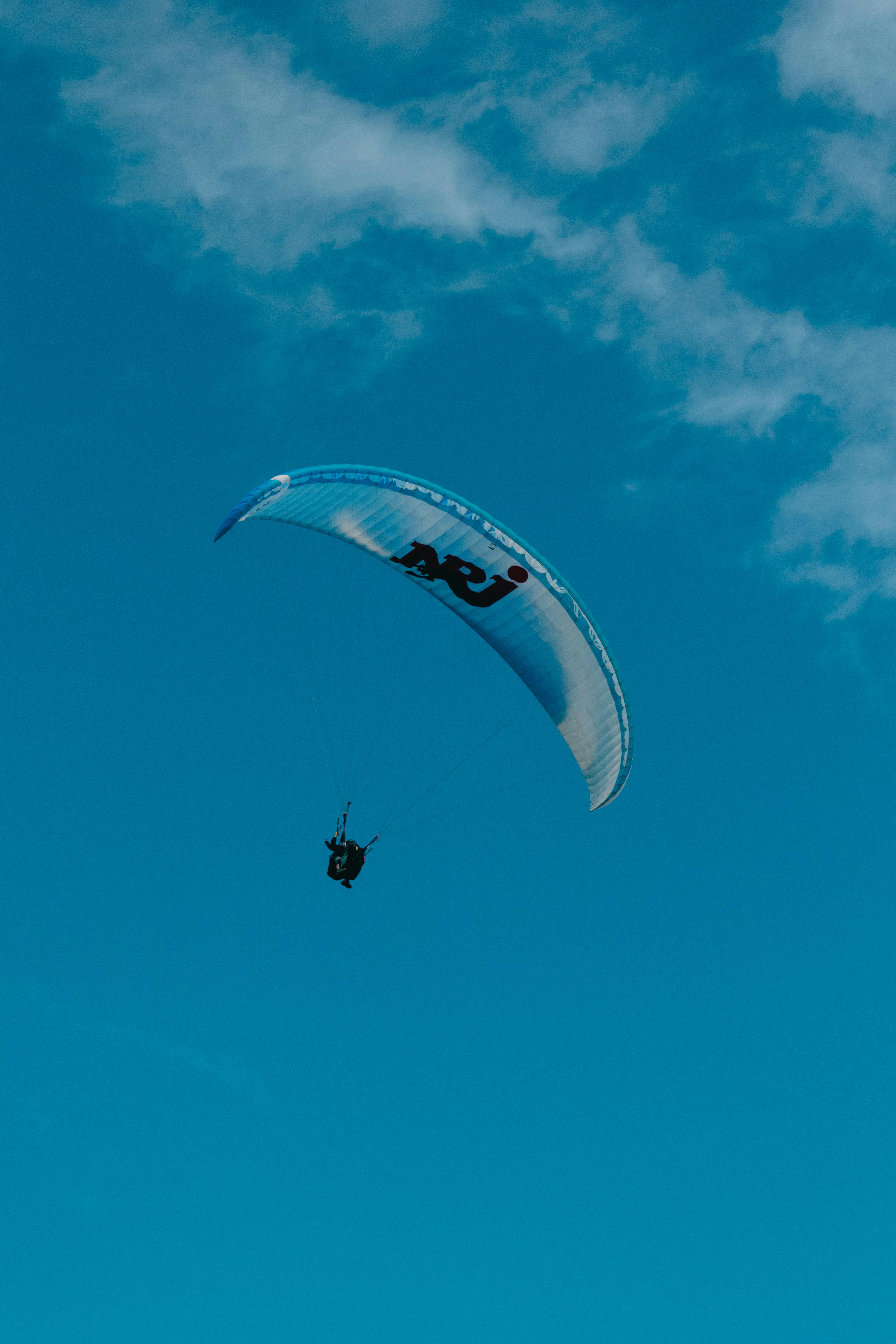 A paraglider soaring in the clear blue sky over La Réunion, capturing the essence of adventure and freedom.