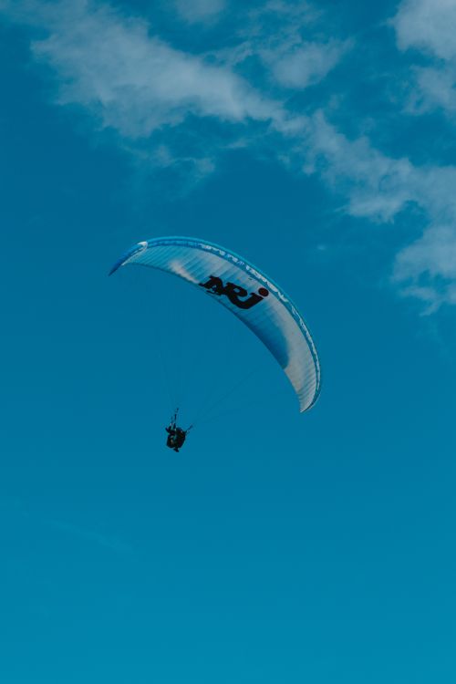 Free A paraglider soaring in the clear blue sky over La Réunion, capturing the essence of adventure and freedom. Stock Photo