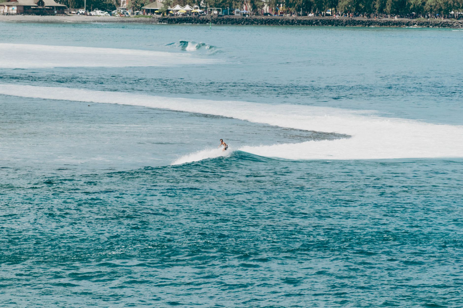 A surfer enjoying the ocean waves off the coast of La Réunion. Perfect tropical scenery.