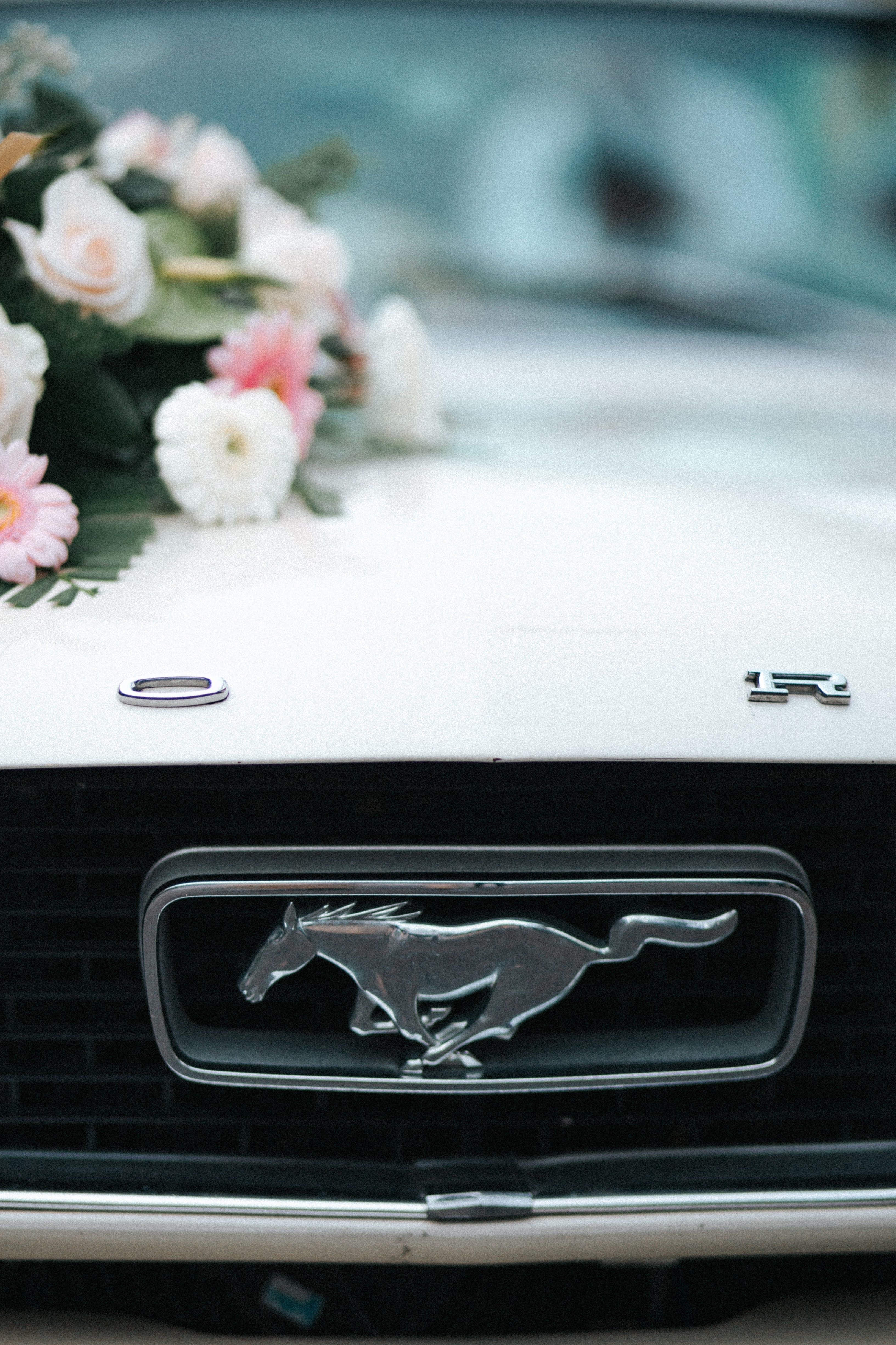 Free Close-up of a vintage car front with wedding flowers, capturing classic elegance and love. Stock Photo