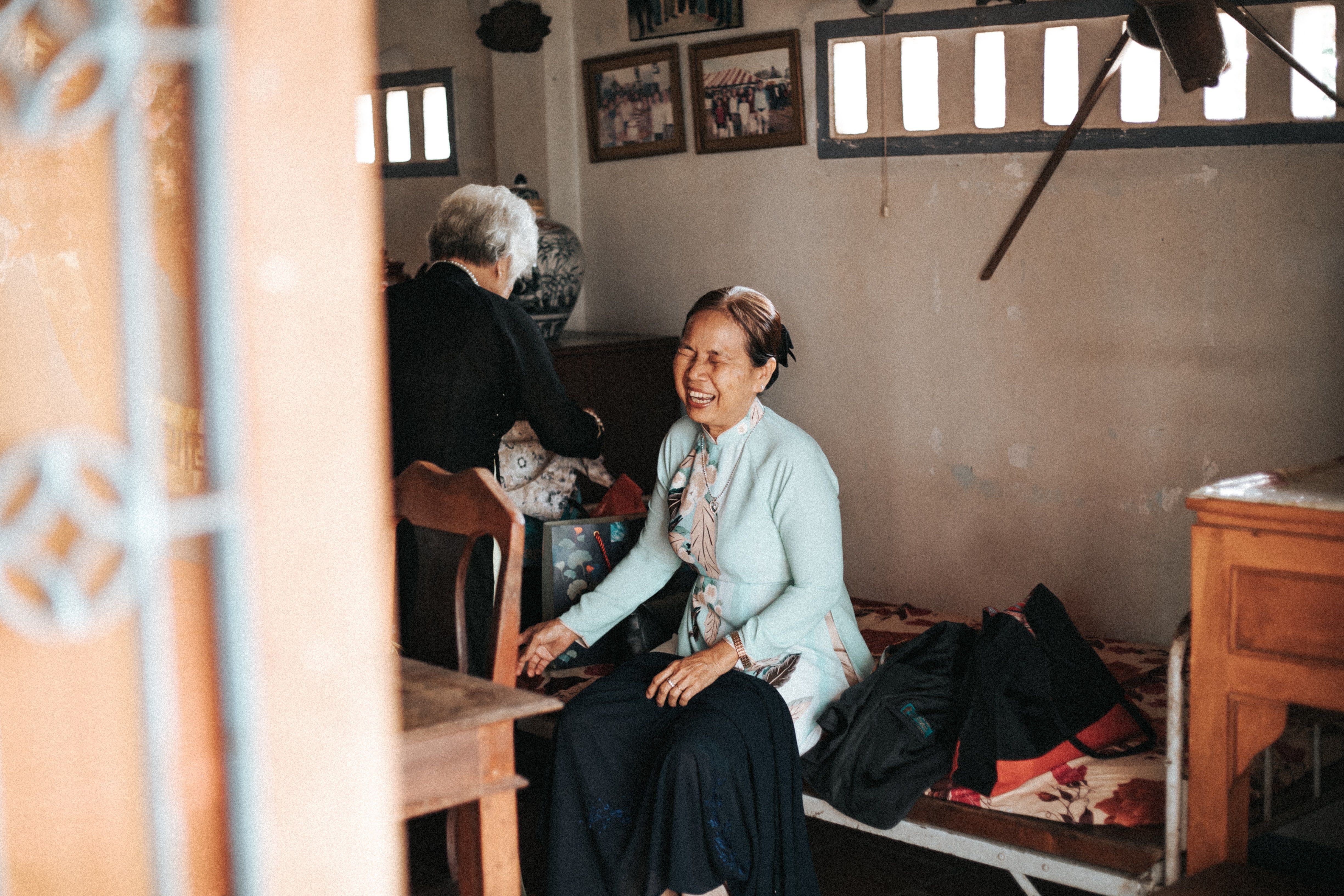 Free Two elderly women sharing a joyful moment in a cozy room setting, showcasing warmth and companionship. Stock Photo