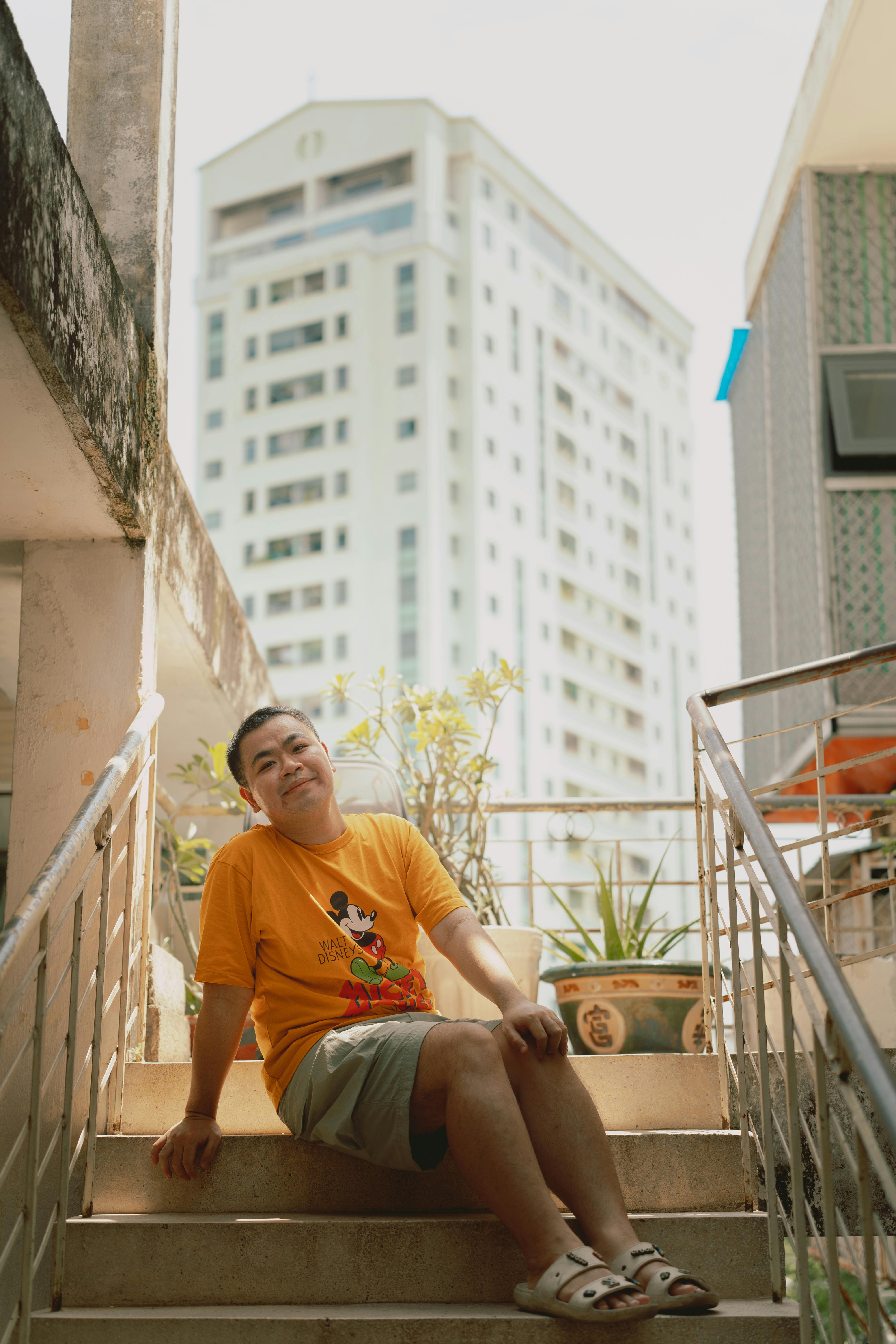 a man sitting on some stairs in front of a building