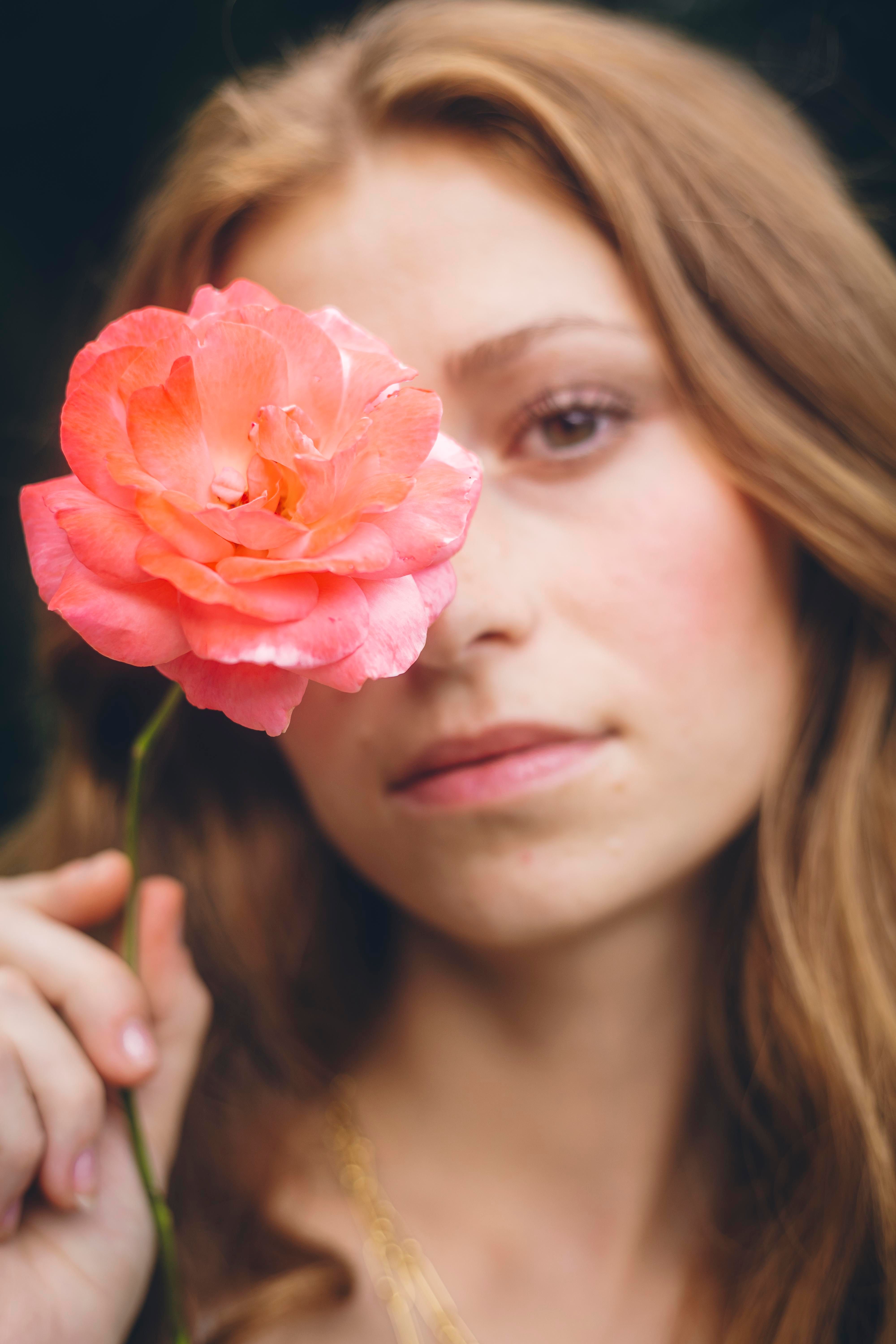 A woman with long hair holding a rose · Free Stock Photo